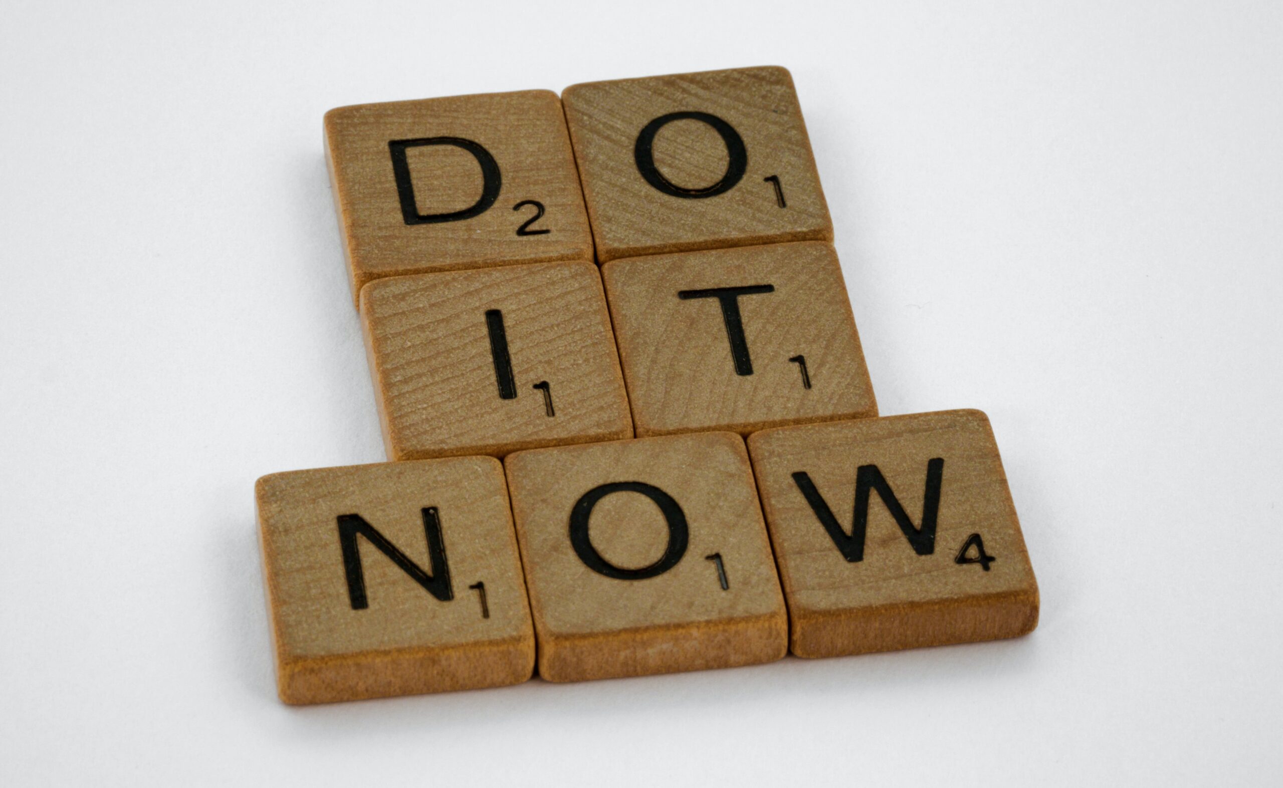 Scrabble tiles spelling 'do it now'